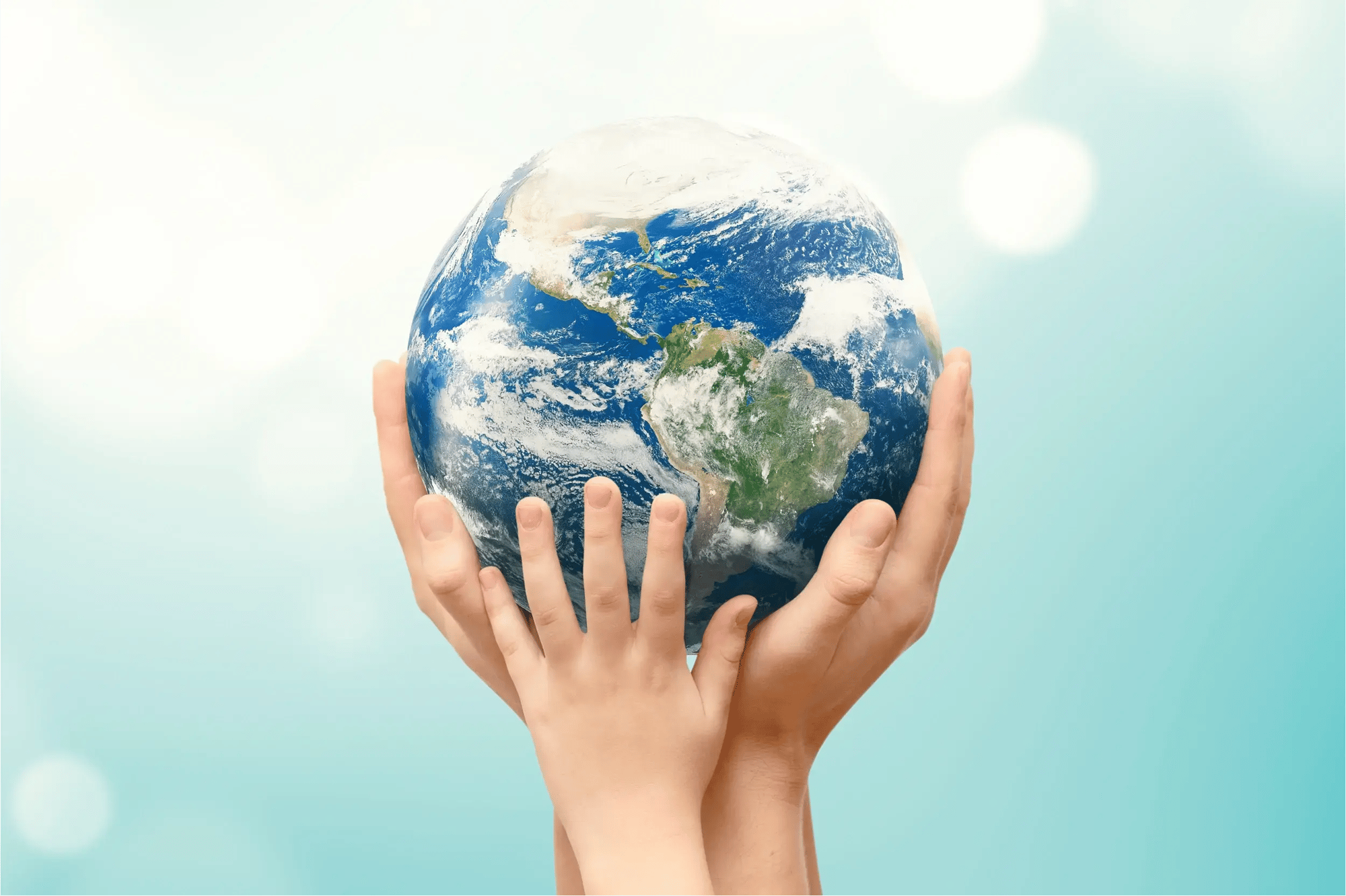 meerdere handen die een wereldbol in de lucht houden
