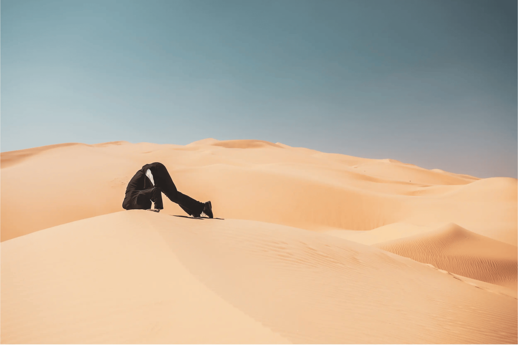 Afbeelding van een man die zijn kop in het zand steekt