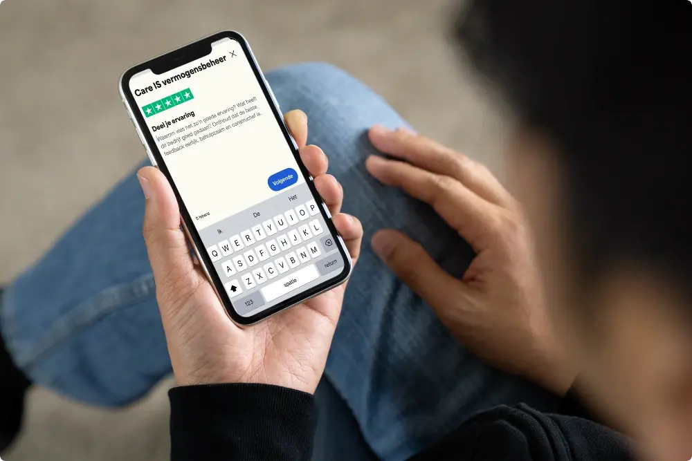 Close up van telefoon met Trustpilot open waar meneer een goede review plaatst